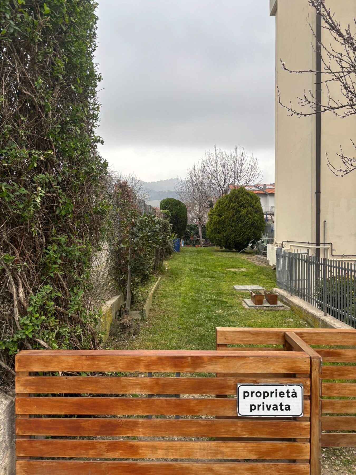Giardino privato con prato curato e cancello in legno
